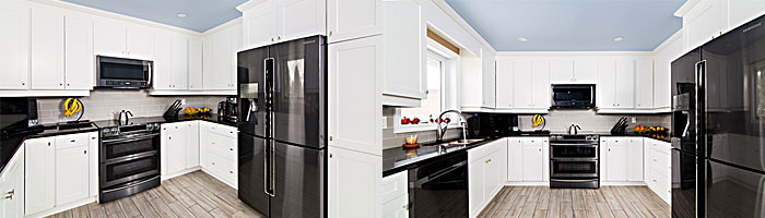 A newly-renovated kitchen with black appliances and white cabinets.